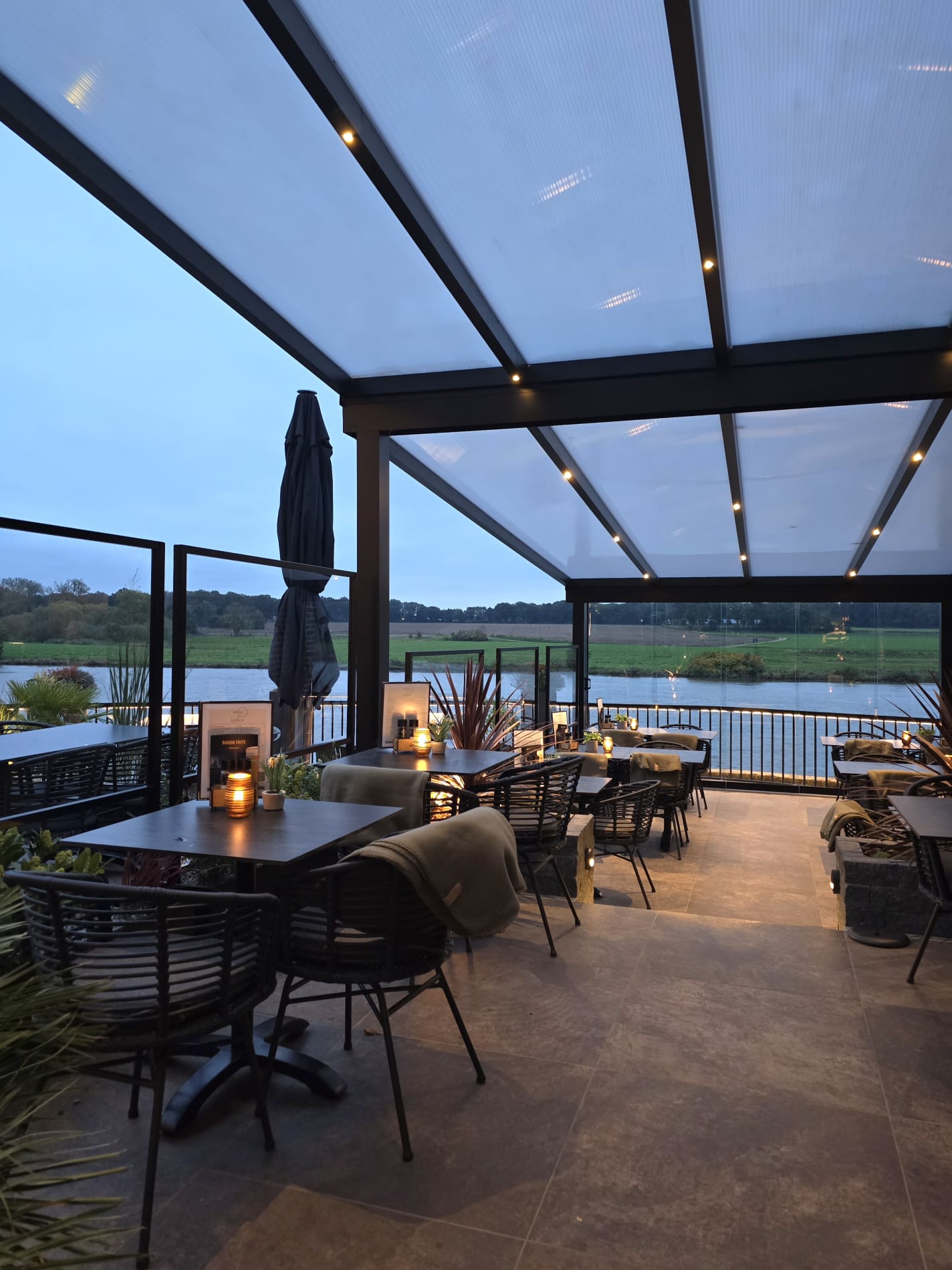 Het overdekte panoramaterras aan de Maas bij schemering